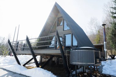 Tahta üçgen kır evi, dağlarda jakuzi kaplıcası olan küçük bir kulübe. Ruh Haftasonları.