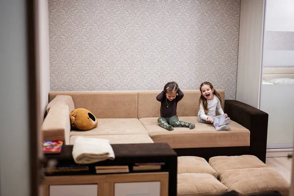 Δύο Αδελφές Στο Σπίτι Στον Καναπέ Γελώντας Δυνατά Μαζί — Φωτογραφία Αρχείου