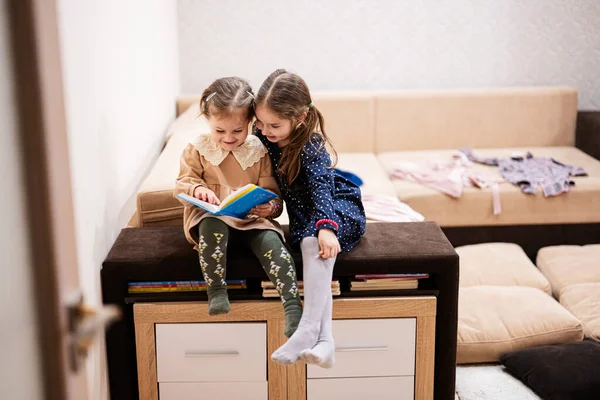 Дві Сестри Сидять Дивані Дивлячись Читаючи Книгу Разом — стокове фото