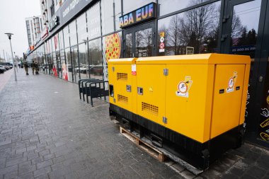 Ivano-Frankivsk, Ukraine - March, 2023: Yellow diesel generator on street. clipart