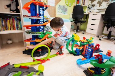 Kyiv, Ukrayna - Mart 2023: Çocuk renkli oyuncak araba koleksiyonuyla oynuyor. Hot Wheels Son Garajı.