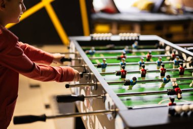 Çocuk oyun merkezinde masa futbolu oynayan çocuk..
