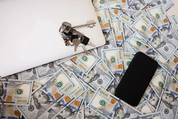 stock image Dollar money with keys, laptop and phone background.