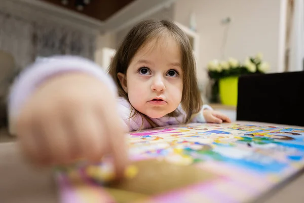 Милая Маленькая Девочка Пижаме Смотрит Книгу Дома — стоковое фото