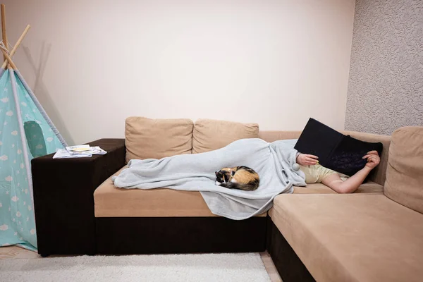 Νεαρή Γυναίκα Ξαπλωμένη Στο Κρεβάτι Και Διαβάζει Βιβλίο Γάτα Της — Φωτογραφία Αρχείου