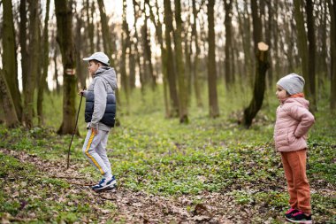Erkek ve kız kardeş bahar ormanını birlikte keşfettiler..