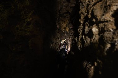 Aile turistleri mağarada geziniyor ve keşfediyorlar..