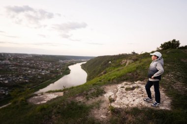 Tatilde yürüyüş yapan bir çocuk, dağın tepesinde durup güzel kanyon manzarasına bakıyor..