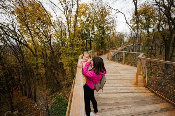 母亲牵着女婴从木桥上看野生动物 — 图库照片