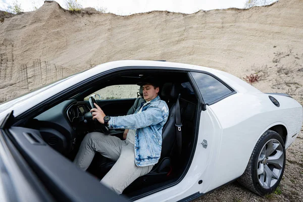 Schöner Mann Jeansjacke Und Mütze Sitzt Seinem Weißen Muscle Car — Stockfoto