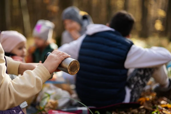妈妈带着孩子在秋天的森林里参加家庭野餐 手拿着热水瓶 — 图库照片