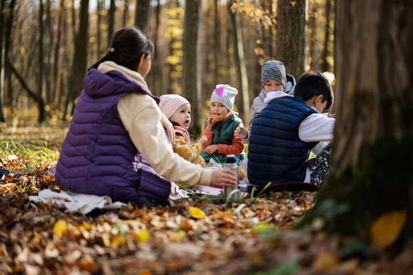 stock image Mother with kids in family picnic at autumn forest. 