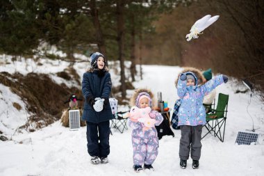 Children in winter forest on a picnic with stuffed toys at hands.