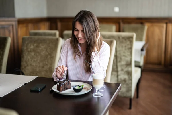 Молодая Улыбающаяся Брюнетка Сидит Кафе Кафе Помещении Ест Шоколадный Десертный — стоковое фото