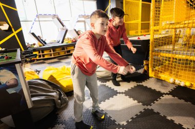 Çocuk oyun merkezinde sensör tarafından modern video oyunu konsolu olan iki kardeş..