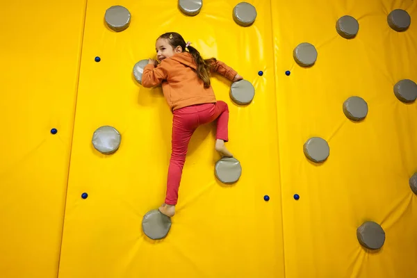 Mała Dziewczynka Wspinająca Się Ścianę Żółtym Parku Zabaw Dziecko Ruchu Obraz Stockowy