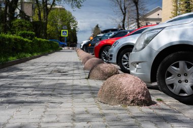 Şehirdeki bir caddede arka arkaya park etmiş arabalar..