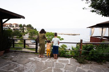 Bulgaristan 'ın Nessebar kentinde denize bakan anne ve çocukların arka manzarası.