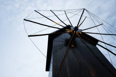 Mavi gökyüzünde beyaz bulutlu yel değirmeni, fotoğrafa yakın çekim. Nessebar, Bulgaristan.