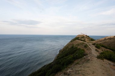 Denizin üzerindeki bir uçurumun tepesindeki deniz feneri, Emine Burnu, Karadeniz kıyısı, Bulgaristan.