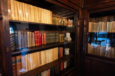 Bran, Brasov, Romanya- Haziran 2023 Klasik edebiyat koleksiyonu ile dolu eski bir ahşap kitaplık, tarih ve bilgi duygusunu çağrıştırıyor..