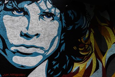 Lutsk, Ukraine - March, 2024: Vibrant urban graffiti art depicting a famous rock musician Jim Morrison from the Doors on a textured dark wall, exuding a retro vibe. clipart