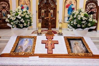 Ternopil, Ukrayna - Mayıs 2023: Dini simgeler, haç, mum lambaları ve çiçeklerle dolu bir Hıristiyan kilise sunağına samimi bir bakış..