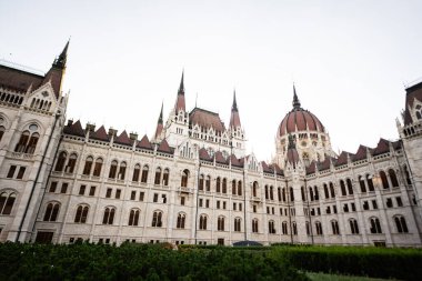 Karmaşık Gotik mimari ve açık gökyüzü arkaplanının yer aldığı tarihi bir parlamento binasının çarpıcı manzarası.