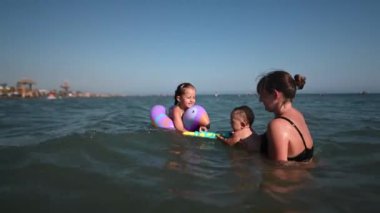 Güneşli bir günde okyanusta oynayan anne ve çocuklar, Karadağ 'ın Ulcinj kentinde aile tatili ve yaz tatili kavramları için mükemmel..