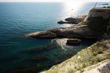 Karadağ 'ın Ulcinj kentinde güneşli deniz manzarası ve engebeli uçurumlar dinlenmek için ideal. Huzurlu bir deniz manzarasında kayalık bir kıyı şeridiyle yakalanan bu görüntü sakinliği ve doğal güzelliği simgeler..