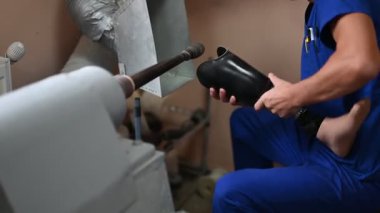 Bir teknisyen, tıbbi cihaz oluşturma ve insan hareketliliği desteğindeki sanatsallığı vurgulayarak, ayrıntılı ve zanaatkarlık üzerine odaklanarak protez bir uzvu parlatıyor..