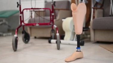 Rehabilitasyon merkezine yerleştirilen protez bacağa yakın plan. Arka planda umut ve iyileşmeyi sembolize eden tıbbi ekipmanlar var..
