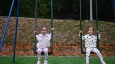 İki genç kız salıncakta sallanmayı seviyor. Bir yaz günü birlikte gülüp eğleniyorlar..
