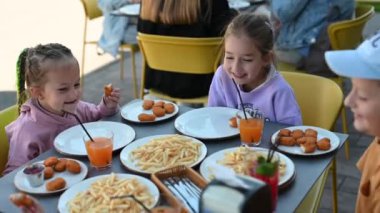 Kardeşler açık bir kafede birlikte fast food ve meyve suyu içmeyi severler. Gülüyorlar, konuşuyorlar ve eğleniyorlar..