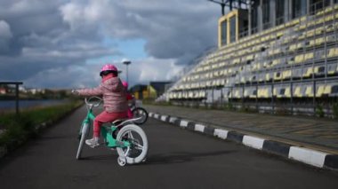 İki mutlu çocuk bulutlu bir günde bir stadyumun yakınında bisikletleriyle geziyorlar. Aktif sağlıklı çocukluk, egzersiz, eğlence, oyun ve oyunlar.
