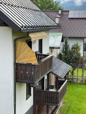 Kırsal ahşap balkonları ve Avusturya 'da çekilebilir tenteleri olan büyüleyici bir Alp tarzı ev. Sahne, dağlık bir kırsal bölgenin sakinliğini ve manzaralı güzelliğini yakalıyor..