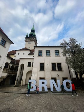 Brno, Çek Cumhuriyeti - 20 Nisan 2022: Şehir merkezinde belirgin bir BRNO işareti bulunan klasik Avrupa mimarisi manzarası. Görüntü, kültürel miras ve modern yaşamın büyüleyici bir karışımını yakalıyor..