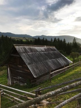 Huzurlu bir dağ taşrasında yerleşmiş kırsal bir ahır. Etrafı yemyeşil ve ahşap çitlerle çevrili. Bulutlu bir gökyüzünün altında yalnızlık ve doğal güzellik hissi uyandırıyor..