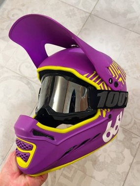 Close-up of an eye-catching purple motocross helmet with yellow accents, featuring a protective visor. Ideal for safety enthusiasts and sports professionals. clipart