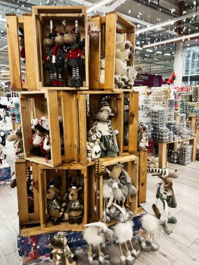 Kyiv, Ukrayna - 02 Aralık 2024: Bayram temalı bir dükkanda ahşap kasalarda sergilenen şenlikli pelüş oyuncaklar koleksiyonu. Sahne Noel süslemeleriyle dolu..