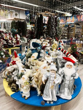 Kyiv, Ukrayna - 02 Aralık 2024: Bir festival dükkanında hazırlanmış çeşitli kostümler içindeki canlı Noel Baba figürleri koleksiyonu. Tatil ruhu ve gösterişli Noel dekorasyon fikirleri.