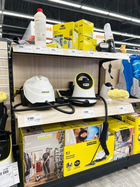 Kyiv, Ukraine - December 15, 2024: Store interior displaying a variety of cleaning tools, including steamers and vacuum cleaners. Organized equipment showcased on shelves.  clipart