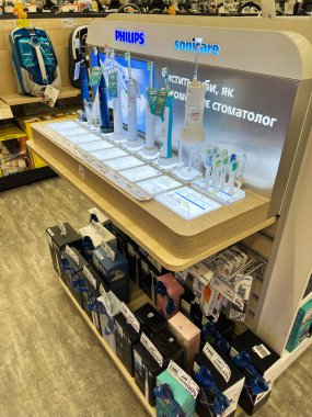 Kyiv, Ukrayna - 15 Aralık 2024: İyi aydınlatılmış bir vitrinde çeşitli elektrikli diş fırçaları ve diş hijyen aletleri sergilendi.