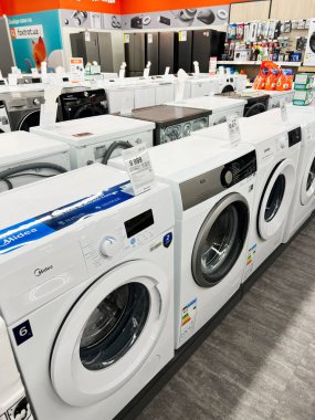 Kyiv, Ukrayna - 15 Aralık 2024: Bir elektronik mağazada çeşitli modern çamaşır makineleri sergilendi, müşterilerin ev aletleri için farklı marka ve modeller sergilendi.