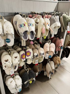 Kyiv, Ukrayna - 18 Aralık 2024: Tüylü tasarımlar ve nakışlı detaylar da dahil olmak üzere farklı renkler, desenler ve şekiller içeren çeşitli terliklerin yer aldığı bir perakende sergisi. Sıcak ayakkabılar daha soğuk mevsimde sıcaklık ve konfor sunar.