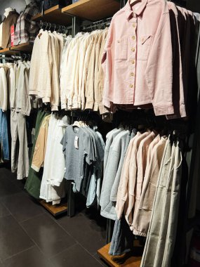 Kyiv, Ukrayna - 18 Aralık 2024: Bir perakende mağazası içindeki raflarda iyi organize edilmiş giysi ürünlerinin sergilenmesi. Düzenleme çeşitli renkler, dokular ve stiller sergiliyor. Modern moda tercihlerine hitap eden bir alışveriş ortamında..