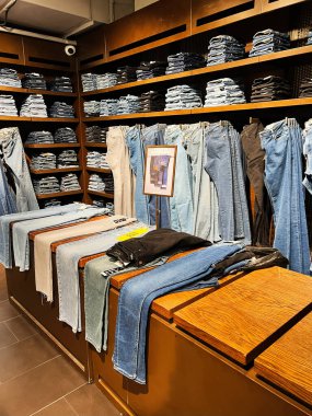 Kyiv, Ukrayna - 18 Aralık 2024: Modern bir perakende mağazasında kot pantolon ve pantolon askısı manzarası. Düzenleme görsel olarak cazip, modaya uygun giyim alışverişi yapan müşteriler için çeşitli stil ve renkler sergiliyor.