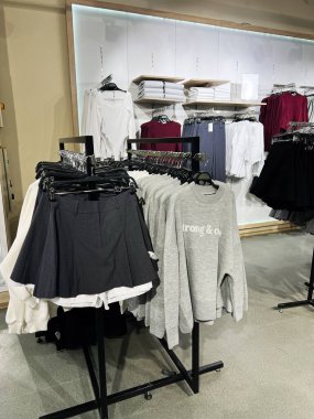 Kyiv, Ukrayna - 18 Aralık 2024: Şık ve organize sunumların vurgulandığı raflarda şık etekler, kazaklar ve gömleklerin sergilendiği parlak perakende mağazası.