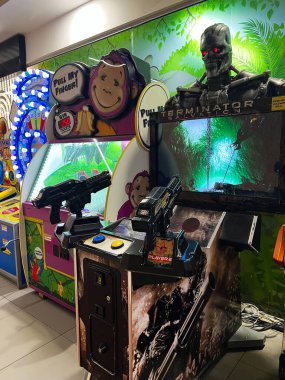 Kyiv, Ukraine - December 18, 2024: Colorful arcade section showcasing themed game machines, including a shooter game with iconic elements, creating an engaging entertainment setup. clipart