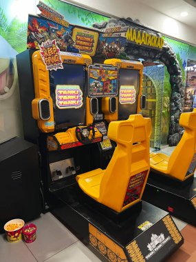 Kyiv, Ukrayna - 18 Aralık 2024: Parlak sarı özellikli atari oyun konsolu, modern bir eğlence merkezinde. 